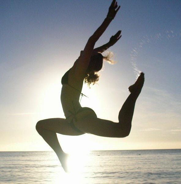 Laura realizando una figura gimnastica frente al mar